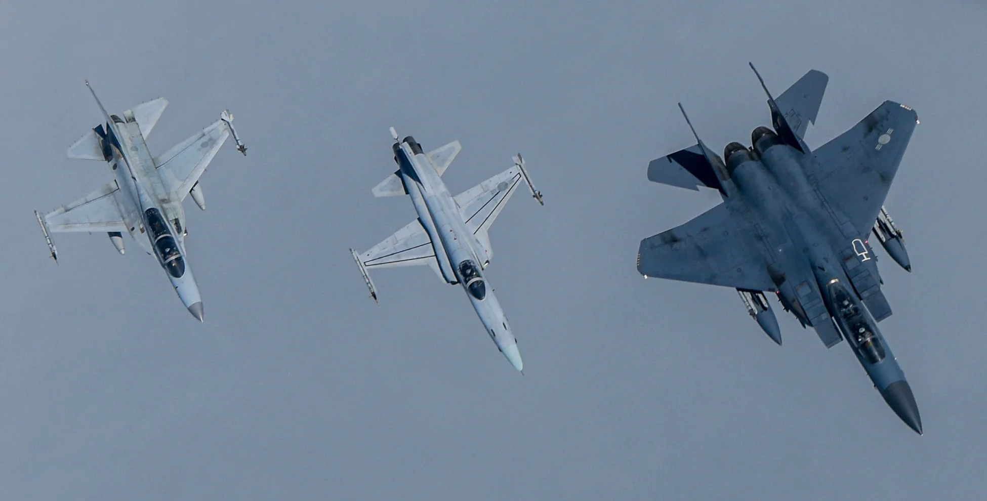 Three U.S. military fighter jets in coordinated aerial maneuver – advanced defense aviation capabilities